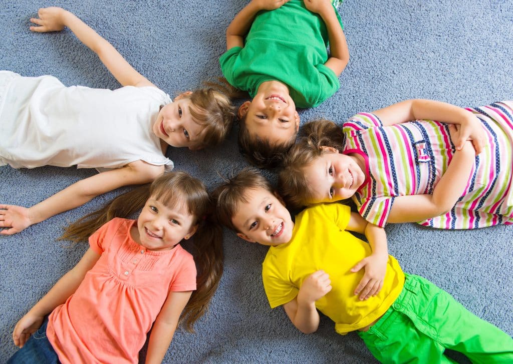 Children lying in a circle on a rug in a day care