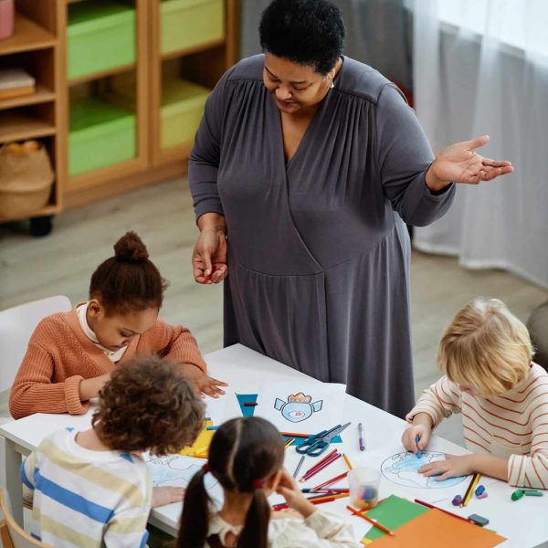 Day care teacher helping children learn